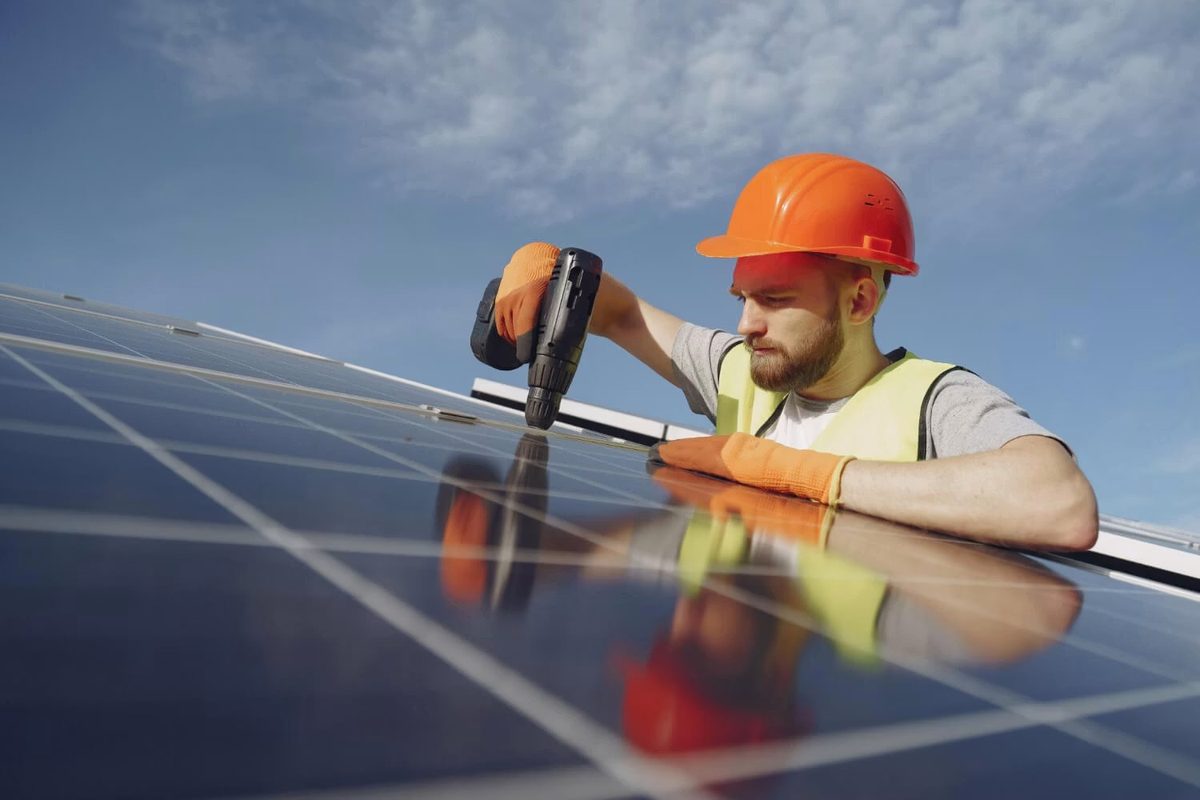 Photovoltaik-Installateur montiert Solarmodule auf einem Dach